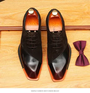 Close-up of suede and polished leather patchwork Oxford shoes with orange sole detail