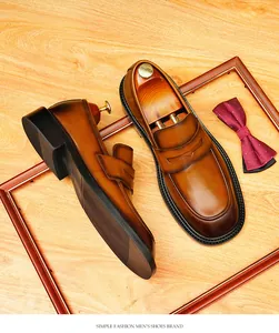 Klassieke bruine leren herenloafers met ronde neus in een formele zakelijke setting