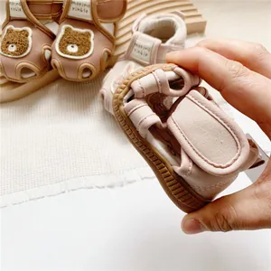 Detail shot of pink cartoon bear baby sandal showing flexible non-slip rubber sole