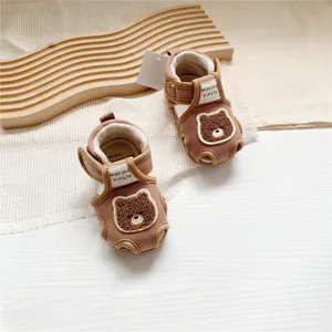 Detailed view of brown baby walking sandals featuring a cute plush bear embroidery design