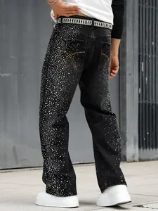 Vue détaillée d'un jean noir ample pour homme orné de strass brillants étincelants