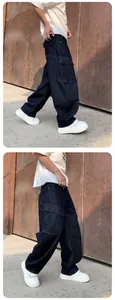 Detail view of dark blue washed loose straight-leg denim cargo pants with side pockets