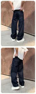 Detailed view of loose straight dark blue washed denim cargo pants with pockets