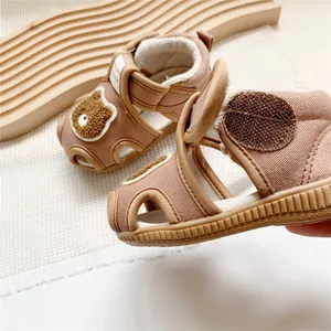 Macro view of baby squeaky sandals featuring a cute bear patch and durable Velcro strap