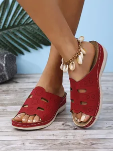 Vue détaillée des sandales compensées rouges pour femmes avec motif floral découpé au laser au sol