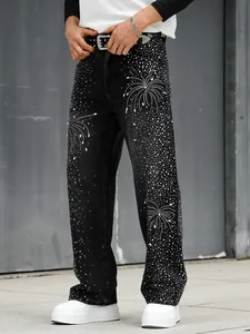 Détail d'un jean droit noir pour homme avec des motifs de feux d'artifice en strass brillants