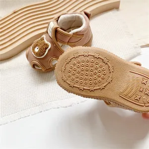 Detail of cartoon baby sandals showing the non-slip sole and cute bear patch design