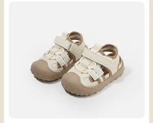 Detailed view of cream toddler sandals with breathable mesh and protective rubber toe cap.