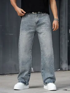 Détail montrant les strass étincelants et les motifs perlés sur un jean droit bleu