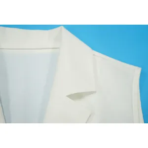 Dettaglio del colletto di una tuta smanicata in lino bianco con cuciture raffinate.