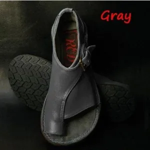Detail view of gray toe-loop flat sandals featuring adjustable buckle strap