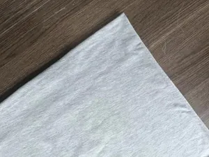 Macro detail of high-quality grey knitted polo shirt fabric showing double-needle stitching