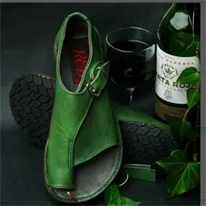 Detail view of green leather toe-loop sandals with buckle strap and rubber sole