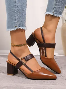 Close-up of brown pointed-toe block heel slingback shoes with metallic ring detail