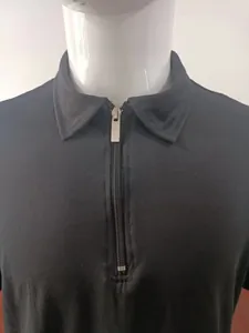 Detail of black men's polo shirt featuring a silver half-zip and classic knit collar.