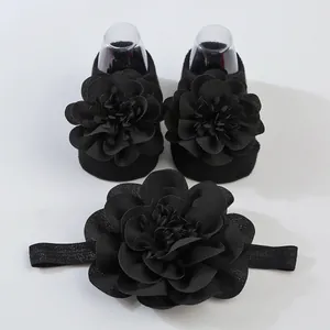 Primer plano de set de calcetines y diadema para bebé con grandes flores de gasa