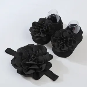 Detalle de conjunto de calcetines y diadema para bebé negros con flores de tela