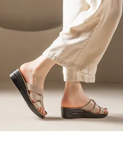 Gros plan de femme portant des sandales compensées en cuir beige à plateforme