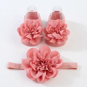 Primer plano de las grandes flores de gasa rosa en calcetines para bebé y diadema a juego