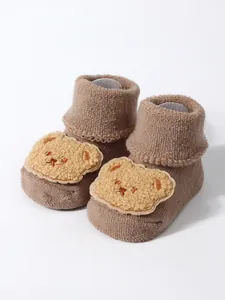 Detailed view of brown thick baby floor socks featuring a cute plush cartoon bear patch decoration