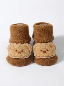 Detail of thickened terry baby socks with plush bear face patch decoration