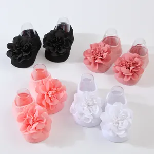 Cuatro pares de calcetines para bebé con grandes flores de gasa en varios colores