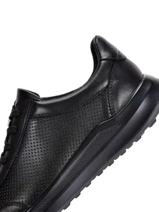 Κοντινό πλάνο μαύρου δερμάτινου sneaker με διάτρητες λεπτομέρειες που αναπνέουν