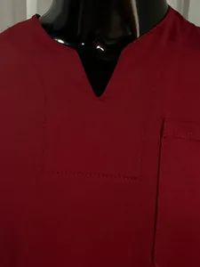 Close-up detail of a burgundy V-neck gym t-shirt with a chest pocket and stitching