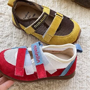 Detailweergave van ademende mesh kinderschoenen met suède rand en klittenbandsluiting.