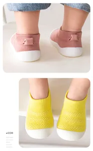 Detail of breathable mesh toddler walking shoes with soft soles in yellow and pink.