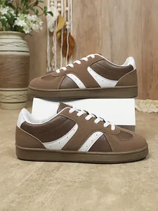 Gros plan détaillé montrant la texture et le blocage des couleurs des baskets brunes.