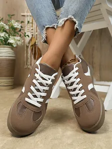 Baskets rétro pour femmes en marron et blanc, style armée allemande avec jeans.