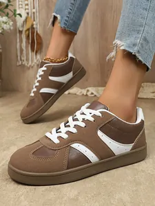 Vue détaillée de baskets vintage marron et blanc pour femmes avec texture en daim.