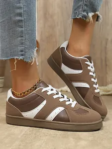 Vue détaillée de baskets rétro marron et blanc style German Army Trainer pour femmes.