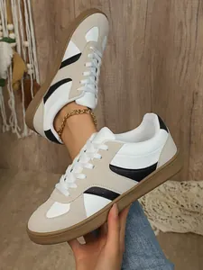 Gros plan sur baskets rétro femme style GAT en cuir bicolore avec semelle en gomme