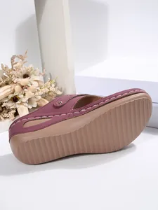 Detail view of burgundy wedge flip-flop with anti-slip textured sole and rivets