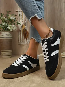 Gros plan de baskets rétro GAT pour femmes en noir et blanc avec une semelle en gomme épaisse