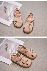 Detail of beige girls' closed-toe sandals with buckle strap and soft sole for summer.