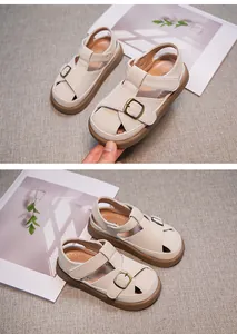 Detail of off-white closed-toe girl's sandals with soft brown sole and buckle strap