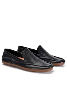 Gedetailleerd zijaanzicht van zwarte echt lederen herenloafers met een zachte rubberzool