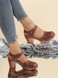 Close-up of vintage brown closed-toe sandals with hollow-out design and block heel.