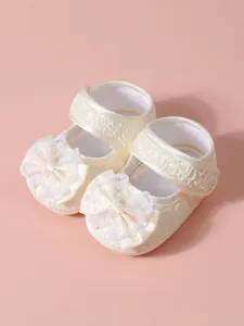 Gros plan de chaussures de princesse pour bébé en dentelle avec nœud et semelle souple