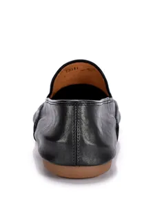 Macro-detail van zwarte leren herenloafers die hielstiksels en een zachte zool tonen