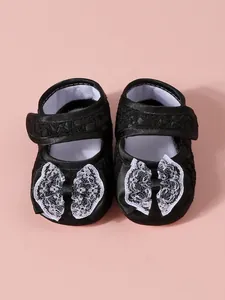 Détail rapproché de chaussures de princesse noires pour bébé avec nœud en dentelle