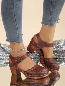 Detailed view of women's vintage hollow-out brown closed-toe sandals with chunky heels