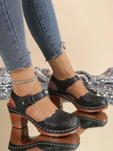 Detailed view of women's vintage black hollow-out closed-toe sandals with chunky heels.
