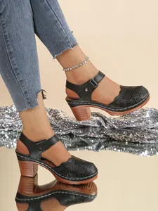 Elegant black perforated closed-toe sandals with chunky heels and ankle straps for women