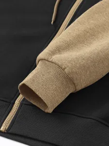 Close-up of color-block hoodie detail showing ribbed cuff and metallic zipper texture