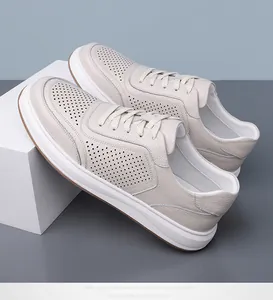 Detailopname van beige geperforeerde echt lederen sneakers voor heren casual