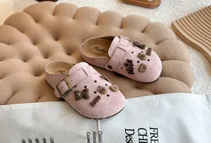 Detail van roze suède Birkenstock-klompen voor kinderen met schattige berenbedels